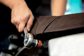 Image is Close up. A Professional  mechanic People are repairing a motorcycle or motorbike use a wrench and a screwdriver to work.