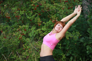 Naklejka na ściany i meble Beautiful sexy woman exercising in the park near the lake.