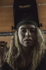 Obraz na płótnie Canvas beautiful girl with long hair in the garage repairing a motorcycle