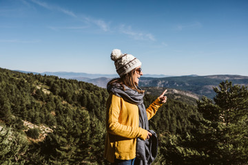 .Young and relaxed woman wearing a yellow sweater, enjoying a sunny winter day in the mountains. Carefree, free and calm. Lifestyle.