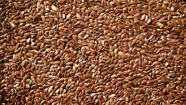Brown raw flax seeds linseed as natural food background or grain texture. Flaxseeds full of omega 3 fatty acids. Top down view. Healthy diet organic nutrition
