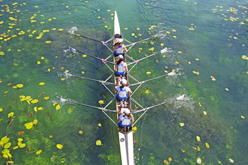Four Womens rowing team on blue lake, Aerial view