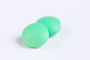 Green pills on a white background. Macro