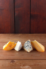 Cheese on wooden boards. Camembert, hard yellow cheese, dorblu on wooden boards. Copy space