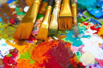 Fototapeta premium workplace painter palette with colors and brushes. Palette of colors, creative disorder, art.
