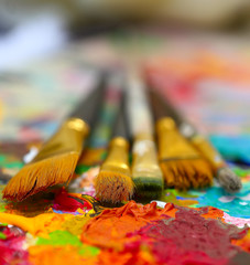Fototapeta premium workplace painter palette with colors and brushes. Palette of colors, creative disorder, art.