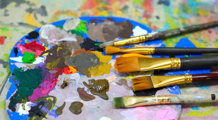 Obraz premium workplace painter palette with colors and brushes. Palette of colors, creative disorder, art.