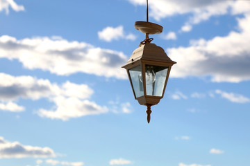 Retro lanterns outdoor, beautiful blue sky with clouds in the background.