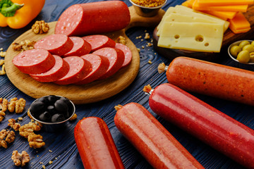 Sliced salami. Sausages assorted with ingredients. Smoked meat products on a wooden table