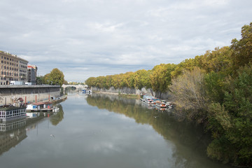 Fototapeta na wymiar River with boats on berth, embankment full of trees
