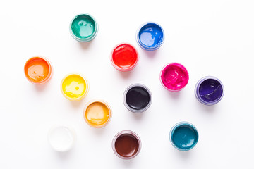 Multicolored gouache on a white background Isolated Paints in containers Top view Copy space