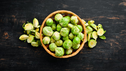 Fresh Brussels cabbage on a black background. Vegetables. Top view. Free space for your text.