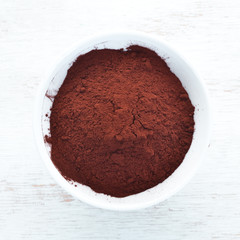 Cocoa powder in a bowl. On a white background. Top view. Free copy space.