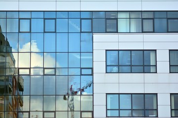 Fototapeta na wymiar Modern building with reflected sky and cloud in glass window