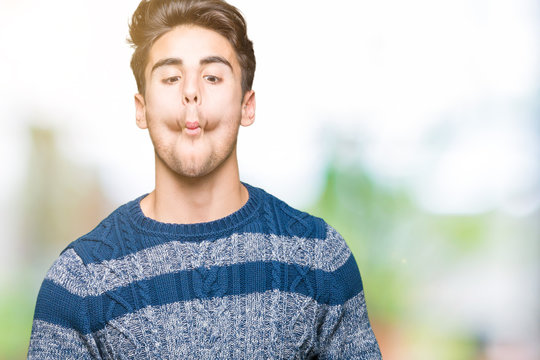 Young handsome man over isolated background making fish face with lips, crazy and comical gesture. Funny expression.