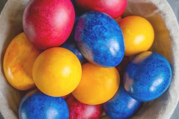 Colorful Easter eggs lying in a basket on a beautiful background. View from above. Easter Brunch