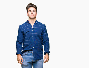 Young handsome man wearing navy shirt over isolated background with serious expression on face. Simple and natural looking at the camera.