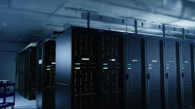 Descending Shot of Data Center With Multiple Rows of Fully Operational Server Racks. Modern Telecommunications, Cloud Computing, Artificial Intelligence, Database, Super Computer Technology Concept.