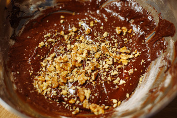  The dough for chocolate cookies with walnuts in a metal bowl. Brownie dough for baking