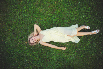 Beautiful young woman lying on the grass. Fresh natural summer concept. View from above.
