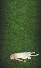 Obraz premium Beautiful young woman lying on the grass. Fresh natural summer concept. View from above.