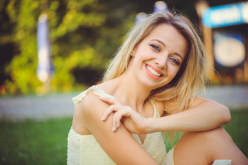 Beauty girl with a gentle romantic smile on the background of summer park. Beautiful happy young woman resting, pastel colors