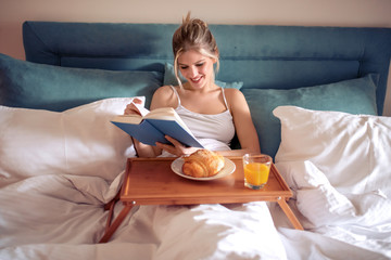 Woman in bed reading a book