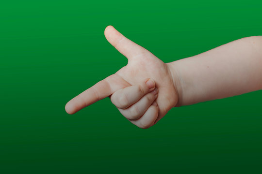Children's hand shows a sign. Isolated on green background