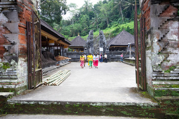 Obraz premium Traditional clothed asian tourist girls walking among shrines at Gunung kawi temple