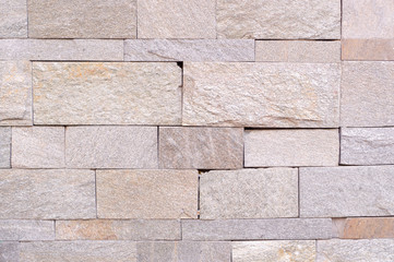 beige weathered stone tiled wall background. texture.