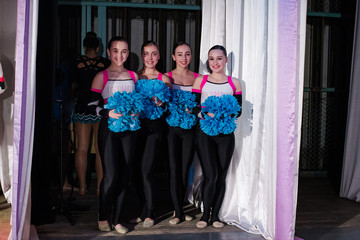 team of young girls - athletes are preparing for the show, many young cheerleaders are standing on...