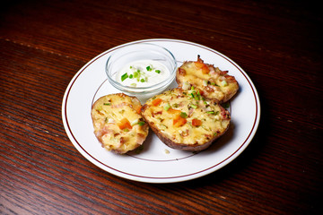 Appetizing dish on a white plate stands on a wooden table, food, snack