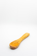 Small light wooden spoon on a white isolated background with blank space for text
