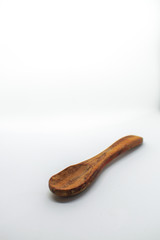 Small dark wooden spoon on a white isolated background with blank space for text