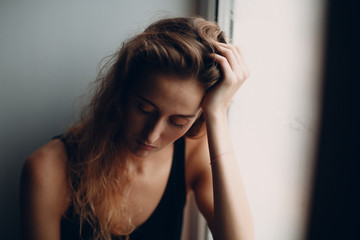 Portrait of young beautiful woman near misted window