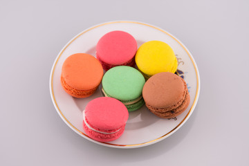 Multi-coloured macarons on a porcelain plate