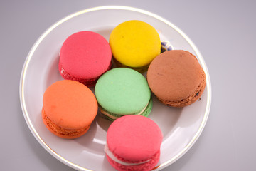 Multi-coloured macarons on a porcelain plate