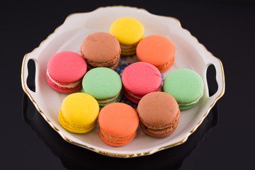 Fototapeta na wymiar Multi-coloured macarons on a porcelain plate