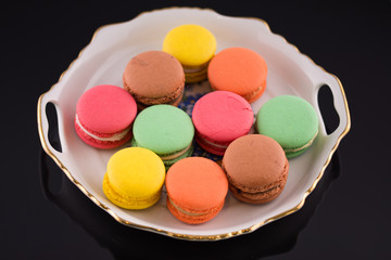 Multi-coloured macarons on a porcelain plate