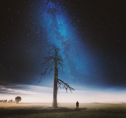 Surreal night and village landscape with field under stars.