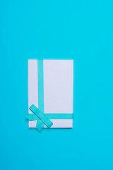 Hands holding craft paper gift boxes with as a present for Christmas, new year, valentine day or anniversary on blue background, top view