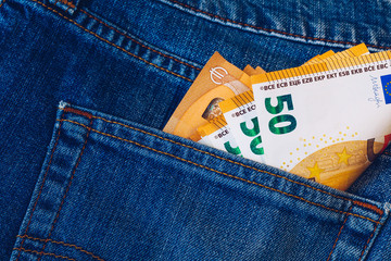 Euro bills in jeans pocket background. Euro banknotes in jeans back pocket. Concept of rich people, saving or spending money. Euro bills falling out. Easy to steal the money. Irresponsible action.