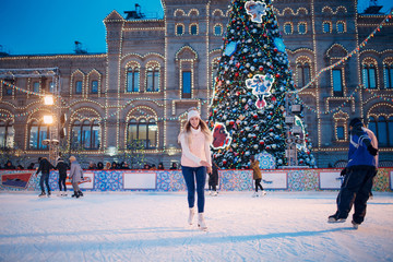 Young woman with skates on the ice rink