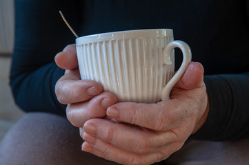 elderly retired woman with hearing impairment received hearing aid of latest modification in center of social protection and tries it on. Help for pensioners and people with disabilities