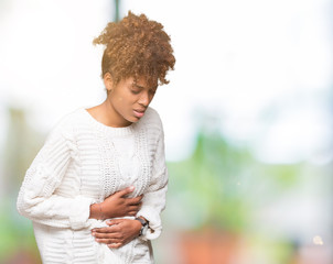 Beautiful young african american woman wearing winter sweater over isolated background with hand on stomach because indigestion, painful illness feeling unwell. Ache concept.