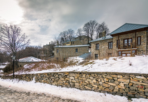 View of traditional stone buildings and streets with snow at the famous village of Nymfaio near Florina, Greece. 