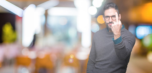 Young handsome man wearing glasses over isolated background Showing middle finger, impolite and...