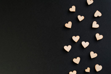 Black background with wooden hearts, place for text.