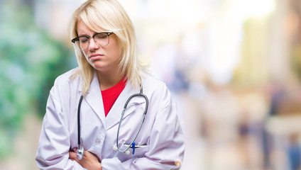 Young beautiful blonde doctor woman wearing medical uniform over isolated background with hand on stomach because nausea, painful disease feeling unwell. Ache concept.