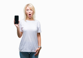 Young beautiful blonde woman showing screen of smartphone over isolated background scared in shock with a surprise face, afraid and excited with fear expression